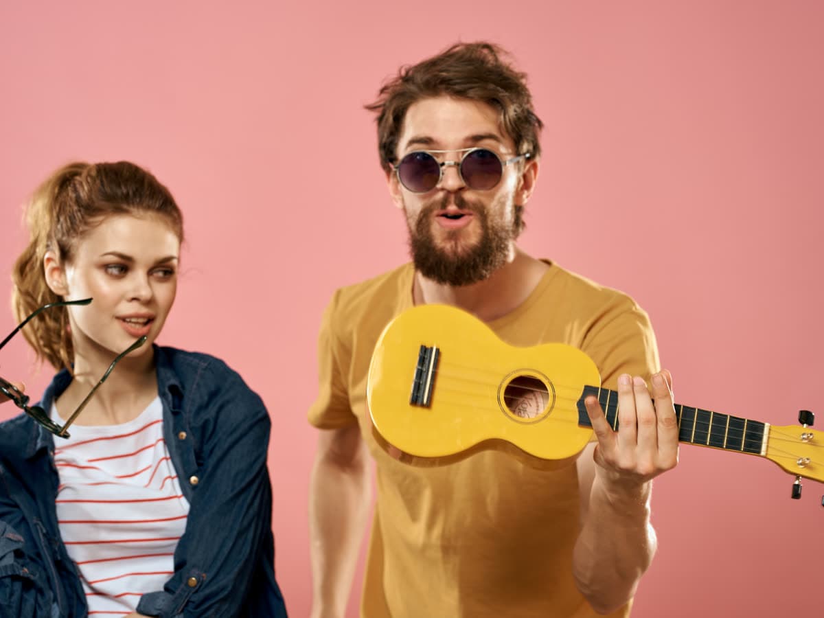 Young adults playing a yellow ukulele